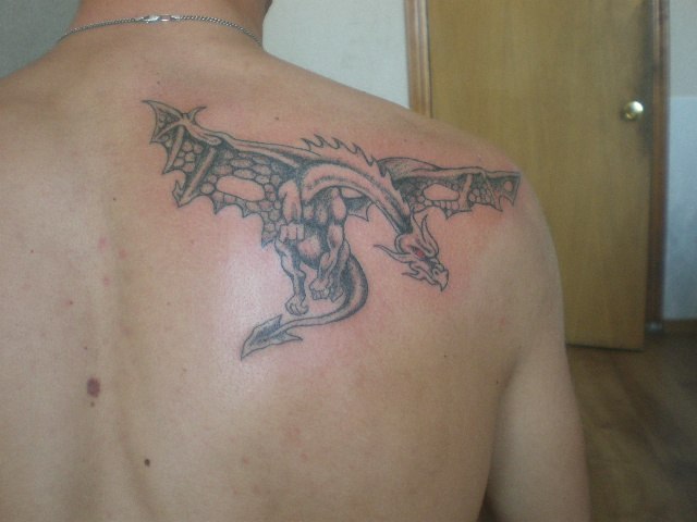 Татуировка дракона на лопатке, выполнена в традиционном стиле