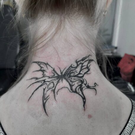 Татуировка бабочка на затылке.